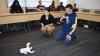 A robot dog sits in front of Assistant Professor Jennifer Kim and a student from the Georgia Tech Excel program.