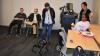 A robot dog stands in the middle of a classroom surrounded by people