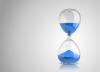 Hourglass with blue sand.