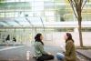 Two students sit outside of Scheller College of Business, laughing and having conversation.