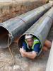 Associate Director of Utilities Maintenance Will Varnado demonstrates the size of the new chilled water pipes in Harrison Square.