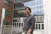 Eric Shen, a Georgia Tech researcher, standing in front of the MoSE Building, an academic building with numerous glass windows