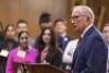 Sen. Sam Nunn stands at a lectern and speakers to an audience