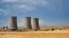  Nuclear power plant cooling towers, big chimneys beside Wheat field with partly cloudy sky in Kurdistan province, Iran. 