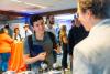 A student speaks to a man over a round table.
