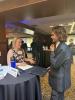 A man and a woman speak with a resume between them.