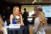 Two women speak over a round table.