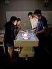 Four students huddle around a lighted table with a virtual human body on it.