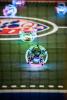 Robot drones fly within a competitive drone soccer cage.