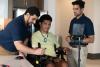 two researchers and a patient in a wheelchair using assistive technology