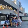 Image of volunteers holding welcome signs outside move-in check-in parking deck.