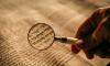 Magnifying glass over Hebrew text.