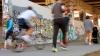 People running, walking and biking along the Atlanta Beltline, graffiti wall in background