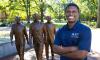 Dean's Scholar Gideon Ndeh on the Georgia Tech campus in front of the Trailblazers statue at Harrison Square
