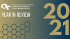 The Sam Nunn School of International Affairs logo, text "Year in Review," a honeycomb design, and a giant 2021 all overlaid on top of a gold to navy gradient.