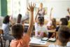 kids raising hands in classroom