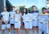Photo of group of students holding Week of Welcome t-shirts.