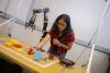 Lakshmi Nair assembles tools on a table next to a robotic arm
