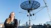 Mariel Borowitz posing in front of a satellite dish on a rooftop.