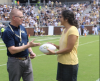 Coach Geoff Collins hands Dr. Jennifer Singh a signed game ball during the GT v. Citadel football game.
