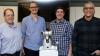 Researchers stand with Shimi the robot.