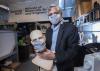 Researcher with mask, holding mannequin with mask
