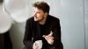 Portrait of Bjarke Ingels, of Bjarke Ingels Group, seated, talking, holding a coffee cup