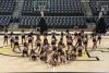 Members of the Goldrush Dance Team stand in various poses on the floor of McCamish Pavilion.