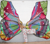 woman posing in front of a large crochet butterfly