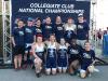 The Triathlon Club stands and kneels in front of a sign for the 2018 National Championships