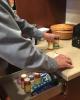 Patient stands at drawer with medications.