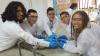 High school students hold substrate with organic film.
