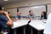 Man sitting among a group of students and leading a discussion