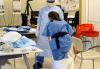 Nurses practice donning and doffing protective gear.